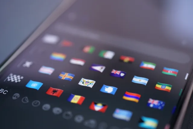 Close-up of a smartphone screen displaying a variety of world flags emojis used for digital communication. Mehrsprachige Inhalte in einem CMS verwalten